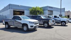 Three trucks parked outside industrial building.