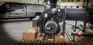 A large industrial diesel engine on display in a warehouse setting.