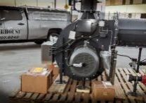 A large industrial diesel engine on display in a warehouse setting.
